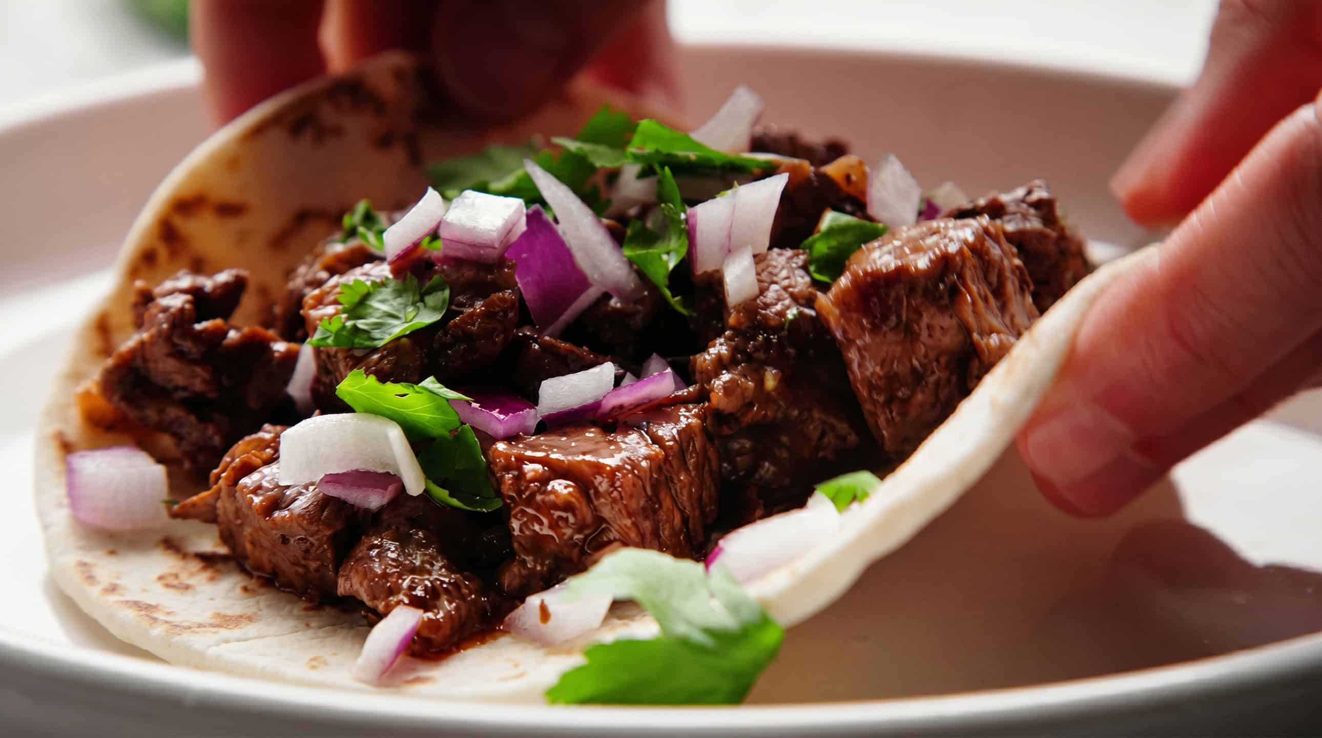 Close-up of a steak taco with cilantro and onion
